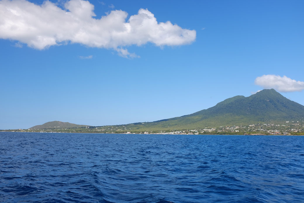 Eine Insel mit zwei Bergen und dem tiefen blauen Meer. Ohne Tunnels und Geleisen und ohne Eisenbahnverkehr... (Später fällt uns auf, dass die Nachbarinsel St Kitts tatsächliche eine Eisenbahn hat. Und zwei Berge.)